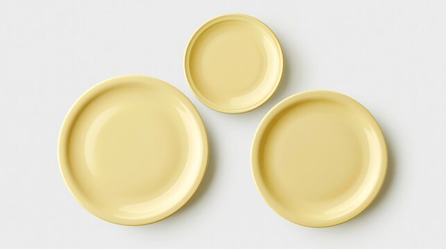 Soft yellow plates arranged in a top view layout on a light background, showcasing three different sizes for versatile dining and serving options