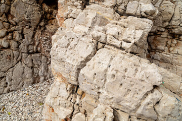 Fototapeta premium Close up view of eroded limestone rock texture in Taurus mountains on a spring day. Rugged porous stone cliff background with karst formation, April, Turkey.