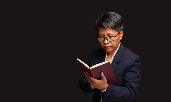 Mature Woman Reading Notebook on Dark Background