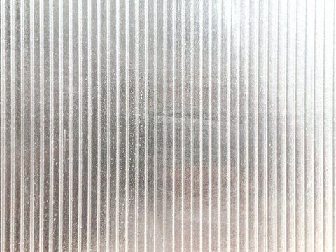 Abstract ribbed texture background of transparent plastic or glass panel with vertical lines pattern