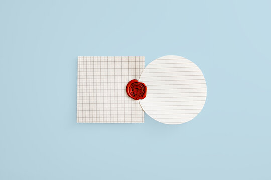 Red wax seal stamp bonding together a round lined paper and square graph paper on a light blue background. Conceptual metaphor for official corporate agreement, business contract, or fusion.