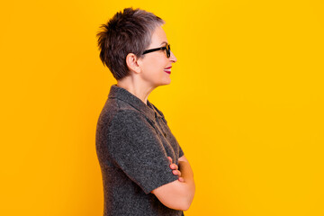 Confident smiling woman in profile with short hair and glasses against a bright yellow background, casual portrait conveying positivity and modern style © deagreez