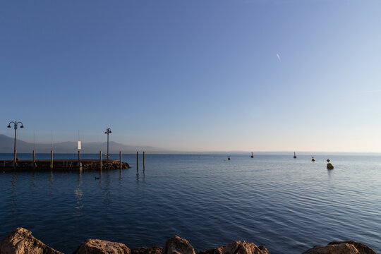 sirmione, lake garda, lombardy, italy, waterfront, lakeshore, pier, sunset, sunrise, calm water, reflection, scenic landscape, travel, tourism, europe