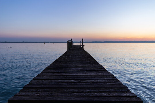 sirmione, lake garda, lombardy, italy, waterfront, lakeshore, pier, sunset, sunrise, calm water, reflection, scenic landscape, travel, tourism, europe