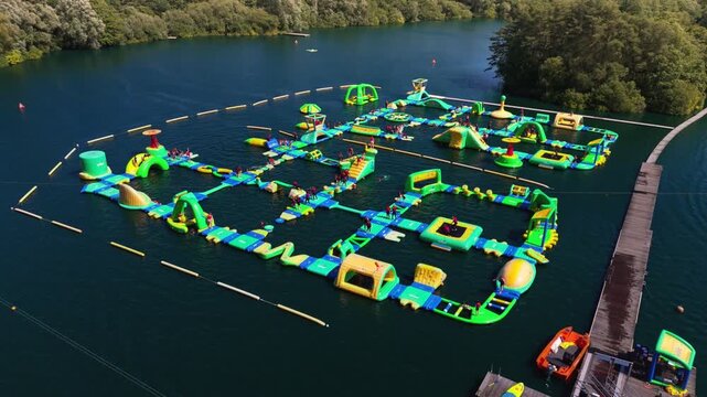 The New Forest Water Park, located near Fordingbridge in Hampshire, England, features one of the UK's first and largest outdoor floating inflatable aqua parks set on a scenic freshwater lake.