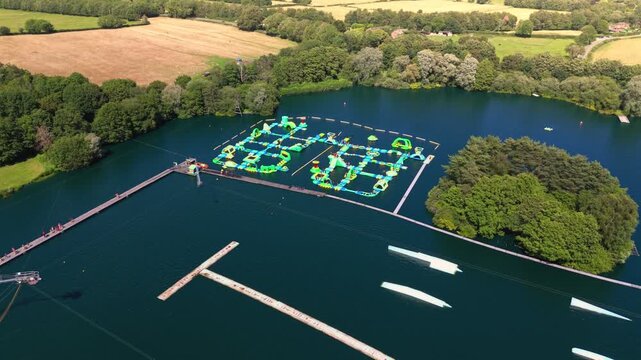 The New Forest Water Park, located near Fordingbridge in Hampshire, England, features one of the UK's first and largest outdoor floating inflatable aqua parks set on a scenic freshwater lake.