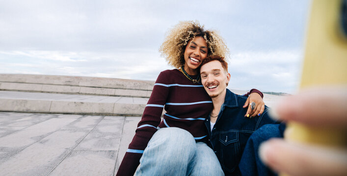 Smiling couple taking a joyful selfie outdoors