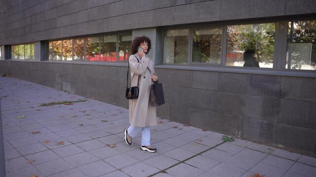 A Young Woman Strolling Through an Urban Park Amidst the Beautiful Autumn Season