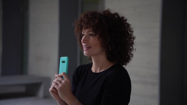 A Young Woman Candidly Engaging with Her Smartphone While Relaxing in a Modern Interior Space