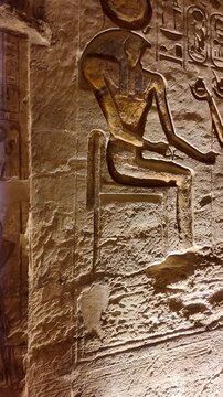 Ancient egyptian hieroglyphs and carvings illuminated on the stone walls inside the great temple of abu simbel. Famous historical landmark
