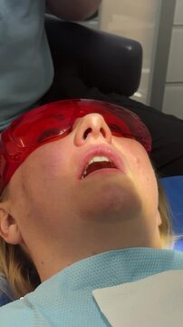woman in dentistry tooth filling injection anesthesia. modern dental treatment with local anesthesia rubber dam filling procedure suction and bite check during professional tooth restoration