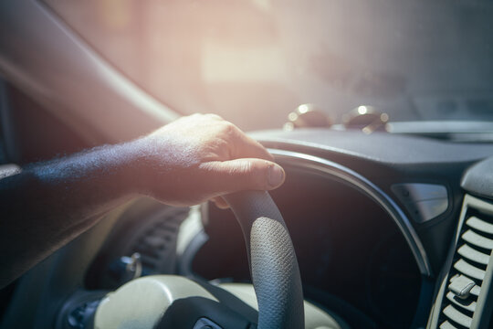 Man driving a car. Close-up of hands on steering wheel