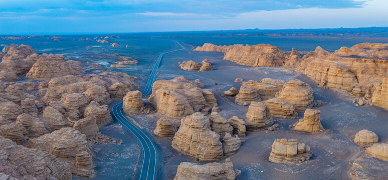 Winding asphalt road through the spectacular yardang landforms in the desert wilderness, Dahai Dao, Xinjiang, China