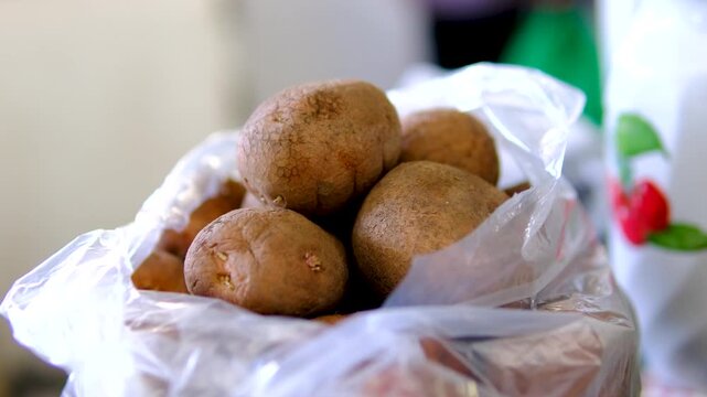 One kilogram of fresh potatoes packed in transparent plastic bag at farmers market ready for sale with natural local harvest and rustic food display
