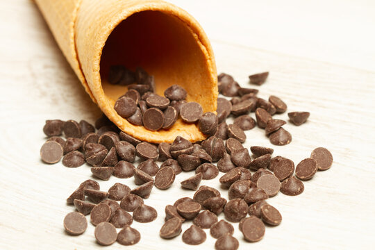 Cono de oblea de helado con pepitas de chocolates sobre un fondo blanco. Vista superior y de cerca. Copy space