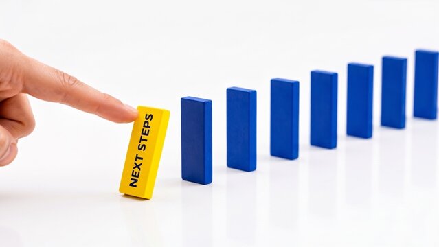 Next Steps domino effect concept with finger pushing yellow block