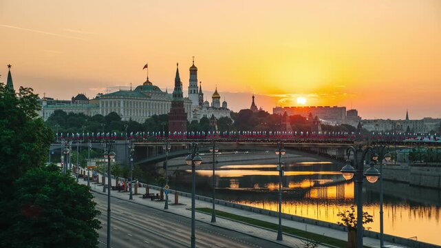 A morning view of the Moscow River, the Kremlin, St. Michael the Archangel's Cathedral, and the Grand Kremlin Palace, with the sun rising over the horizon &mdash; time-lapse photography