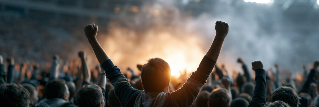 Excited crowd cheering at a live event with raised hands and vibrant atmosphere.