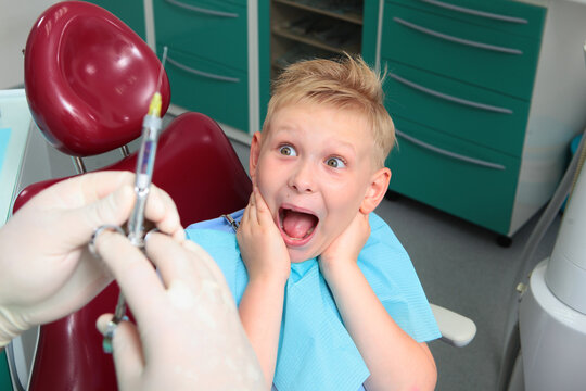 Child is horrified and screams when he sees syringe. Little boy experiences fear at dentist appointment. Childish fear. Fear of dentist