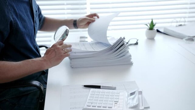 Man analyzing financial documents and calculating taxes, handling a large pile of paperwork and budgeting personal finance for business accounting or administrative tasks