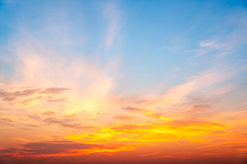 Obraz premium Sunset or sunrise sky with a vibrant gradient of orange, gold, and soft blue. Clear atmosphere with wispy clouds. Peaceful, natural light background. hope, freedom, new day and inspirational Concepts