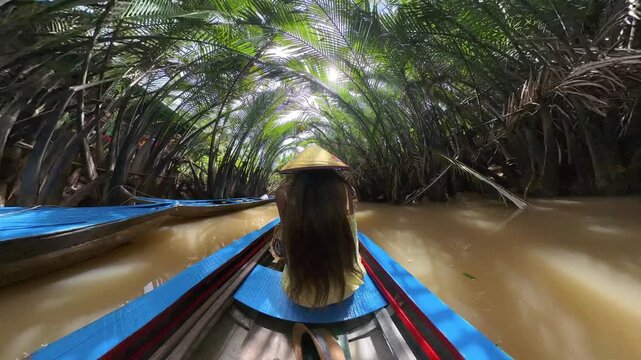 Tourists visit the Mekong River on traditional boats - a girl dressed in an oriental hat in Vietnam during a sightseeing excursion - Asia - 360 shot video 