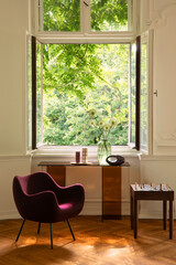 Fototapeta premium Inviting Interior with Bright Window View to Lush Greenery, Modern Chair, and Console Table for Elegant Living