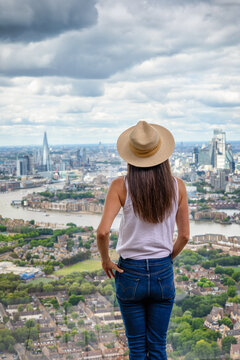 A woman enjoys the panoramic summer view over the city skyline of London, England