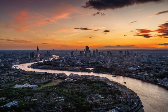 Panoramic, elevated summer dusk view of the illuminated skyline of London, England, with beautiful cloudscape