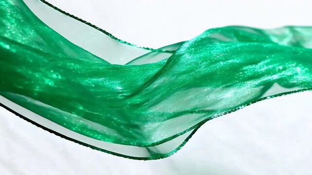 Flowing green fabric on white background