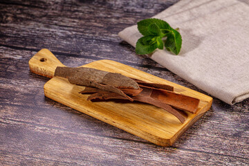 Cinnamon sticks on wooden cutting board with mint leaf © Andrei Starostin