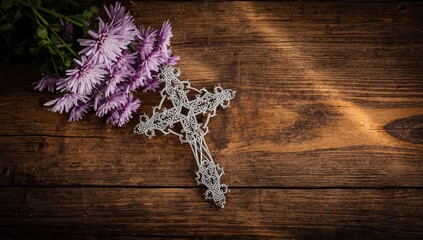 Fototapeta premium Decorative Christian cross and Michaelmas daisies on a wooden surface. Represents Michaelmas Day, September 29th. Prayer, remembrance, Lent, Easter, faith in God. Overhead perspective.