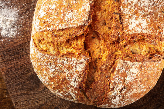 Homemade artisan sourdough bread loaf on a rustic wooden cutting board