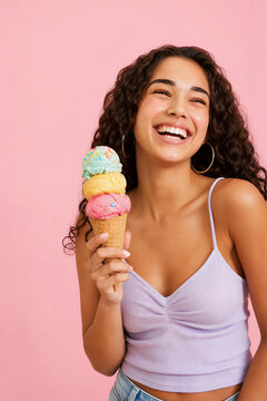 Happy young woman holding colorful triple scoop ice cream cone