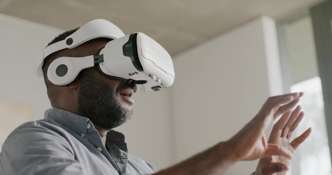 African American man post white VR activation, pointing then framing, sizing object in workspace