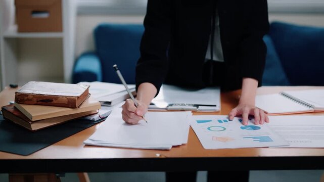 Business Audit Professional Reviewing Financial Charts and Reports with Pencil at Office Desk