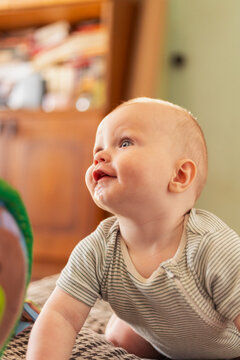 Adorable baby with drool on chin looking up with a happy expression