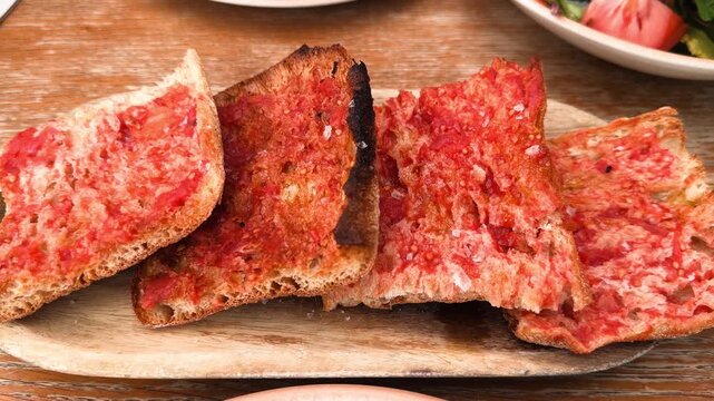Traditional Spanish tomato bread on toasted rustic bread. Close up of Pan con Tomate. High quality 4k footage