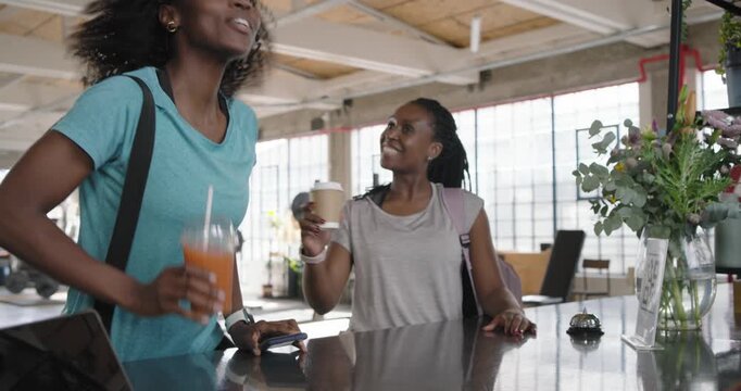 African American women tapping device after man handing taking smoothie, coffee walking for workout
