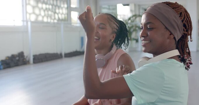 African women raising arm, reaching, laughing, leaning and hugging, playing in studio with headset