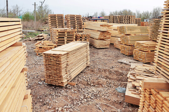 Lumber warehouse. An open-air wood processing workshop. Woodworking. Manufacture of pallets made of wood for cargo transportation. Natural wood