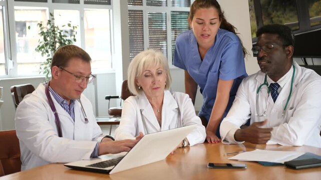 Group of medical people discussing issues at table in office