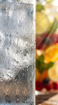 Fresh citrus fruits and herbs in cold water splash with ice close up