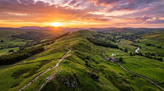 Aerial view of lush green hills during dramatic sunset sky with vibrant colors