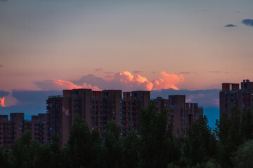 Obraz premium Dark Urban Skyline Against Warm Sunset Clouds