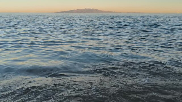 Calm waves at sunset at Lia Beach on Mykonos Island in Greece