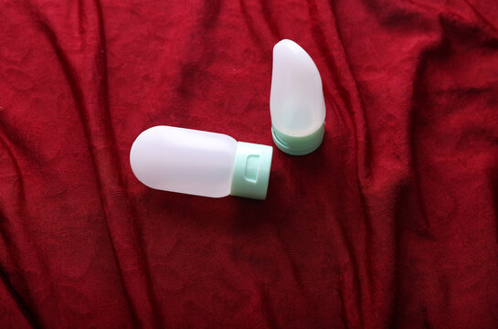 Travel cosmetic bottles on a red fabric background