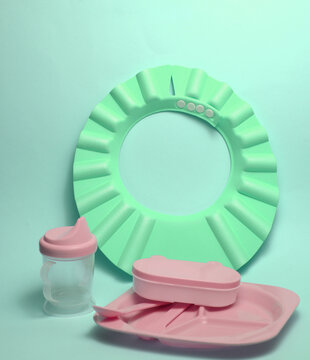 Plastic dishes for feeding a baby on blue background