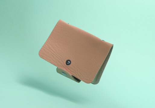 Pink leather business card holder floating on a blue background