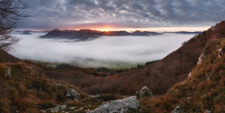 Panorama of autumn mountain over clouds with sun